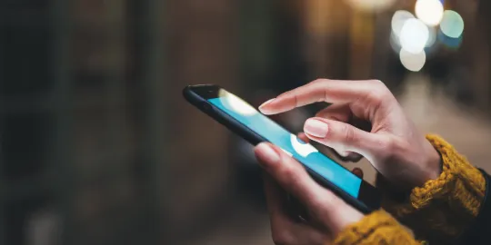 Close-up shot of a person holding a smartphone and tapping the phone screen.
